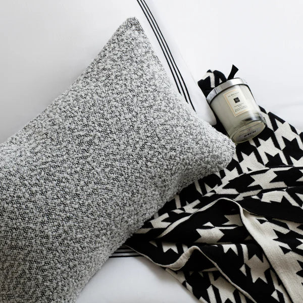 A textured pillow, patterned throw and Jo Malone candle