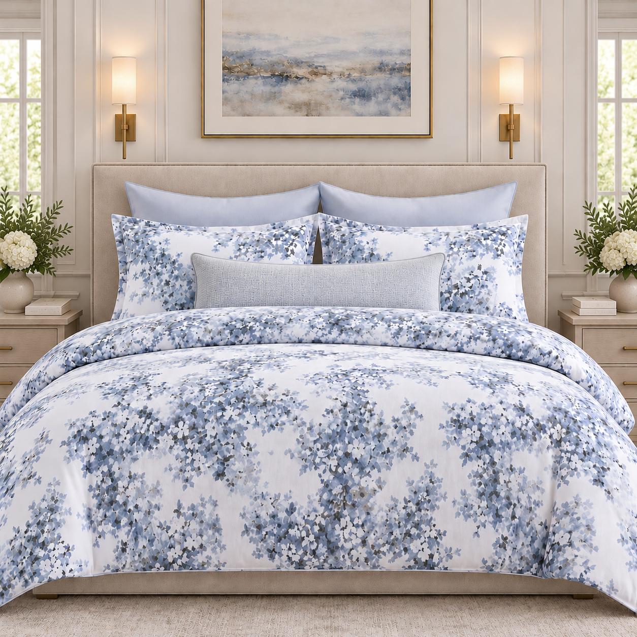 Blue floral bedding with layered pillows in a softly lit bedroom